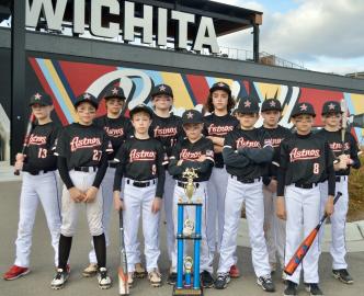 The team members of the 11/12U Astros baseball team strike a pose with their First to the Turf 2022 Championship trophy.